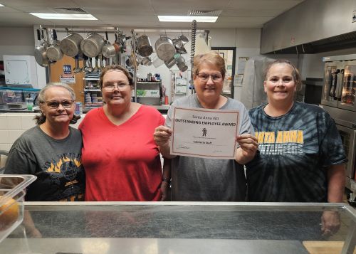 5 ladies in school cafeteria smiling